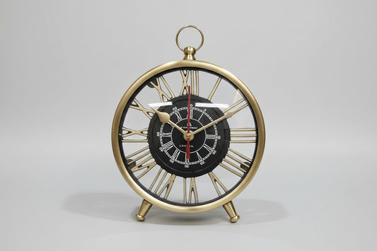Decorative clock with gold frame and black face on a white wall.